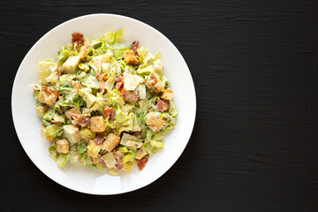 Homemade Bacon Avocado Caesar Salad with Cheese and Croutons, top view. Copy space.