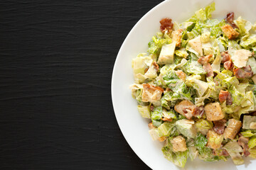 Homemade Bacon Avocado Caesar Salad with Cheese and Croutons, top view. Flat lay, overhead, from above. Copy space.