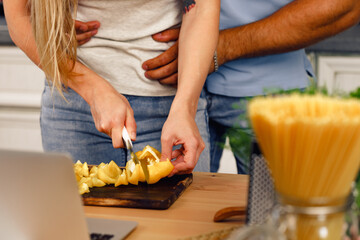 Close up of unrecognizable couple cooking food together in kitchen