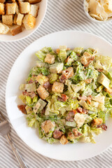 Homemade Bacon Avocado Caesar Salad with Cheese and Croutons, view from above. Flat lay, top view, overhead. Close-up.