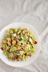 Homemade Bacon Avocado Caesar Salad with Cheese and Croutons, view from above. Flat lay, top view, overhead. Space for text.