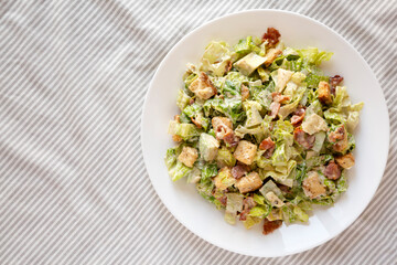 Homemade Bacon Avocado Caesar Salad with Cheese and Croutons, view from above. Flat lay, top view, overhead.