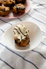 Homemade Chocolate Banana Bread Pudding with Ice Cream on a white plate, side view.