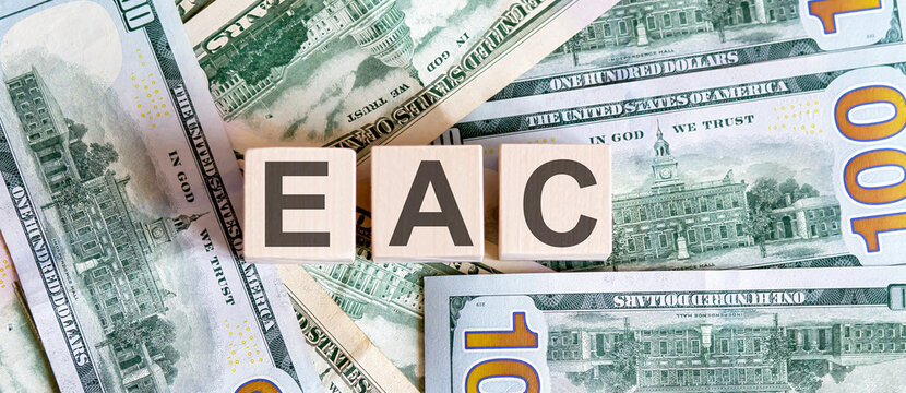Concept words EAC on wooden blocks on a beautiful background from dollar bills.