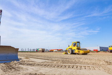 Plate compactor is mounted on road roller to compact soil at construction site