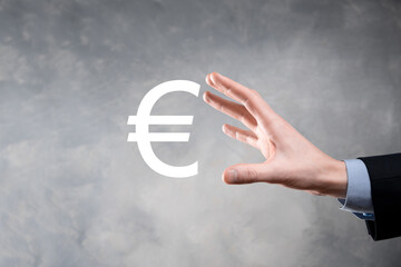 Businessman holds money coin icons EUR or Euro on dark tone background..Growing money concept for business investment and finance