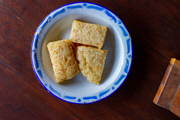 jadah goreng or Fried sticky rice cake served enamel plate. on wood background