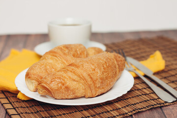 croissants saucer on the table fork with a knife fresh pastries