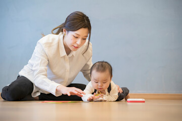 Fototapeta premium 室内で、赤ちゃんと遊ぶお母さん