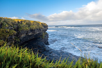 Fototapeta na wymiar View on the Atlantic ocean. Mullaghmore peninsula, county Sligo, Ireland. Blue water with waves, cloudy sky, nobody. Roung stone coastline