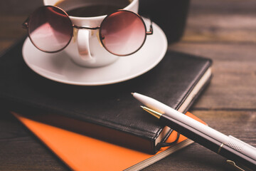 glasses notepads the office handle a cup of coffee saucer wooden table