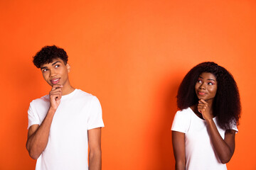 Photo of young happy cheerful thoughtful minded curious african couple thinking look copyspace isolated on orange color background