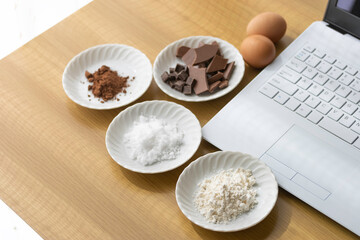 ノートパソコンを見てチョコレート菓子を作るイメージ