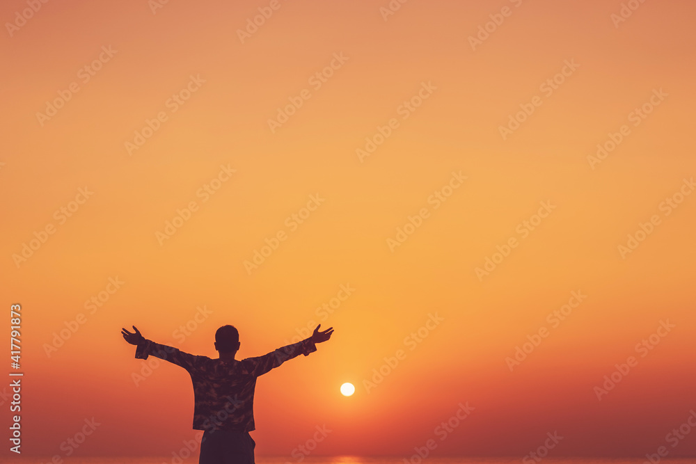 Wall mural copy space of man rise hand up on sunset sky at beach and island background. - Wall murals