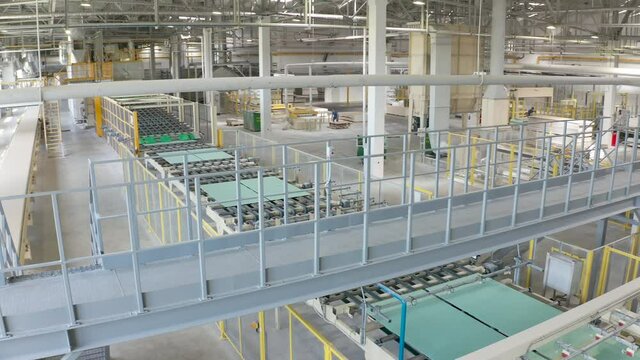 Manufacture of drywall or gypsum board by conveyor on factory. Production of building materials or plasterboard sheet