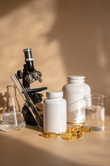 Obraz na płótnie Canvas Laboratory for the creation and study of tablets. Omega 3 capsules. Chemical equipment, flasks and measuring cups. Top Hero. Pills from quality raw materials