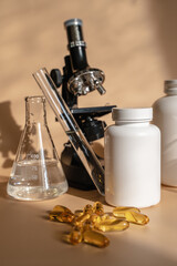 Obraz na płótnie Canvas Laboratory for the creation and study of tablets. Omega 3 capsules. Chemical equipment, flasks and measuring cups. Top Hero. Pills from quality raw materials