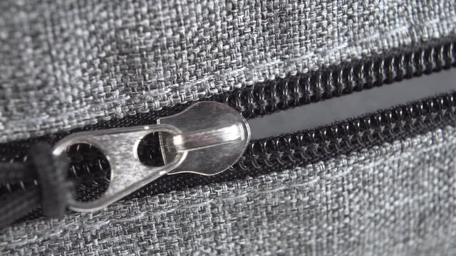 Unzipping the zipper, unpacking the suitcase. Macro shot. Travel concept