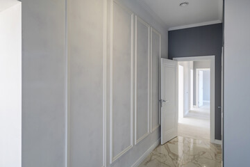 Fototapeta na wymiar long white empty corridor in interior of entrance hall of modern apartments, office or clinic