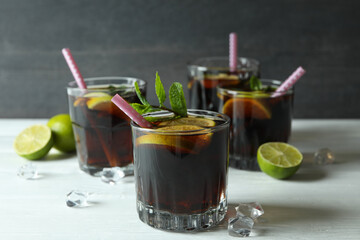 Cuba Libre cocktails on wooden table against dark background