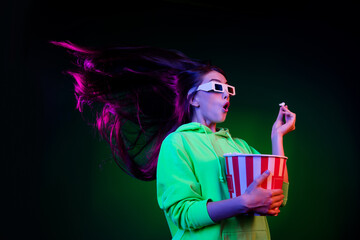Photo of impressed charming young lady wear green sweater watching movie eating popcorn isolated...