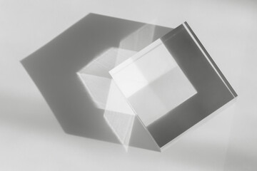 Glass transparent cube with sun reflection, light and shadow on white background. Physics...