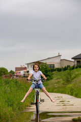 Child, boy, riding bike in muddy puddle, summer time