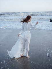 Fototapeta na wymiar Romantic Woman in White Wedding Dress on the Beach by the Ocean