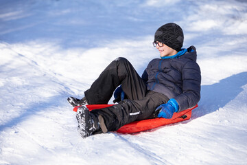 smiling little boy sitting on sled
