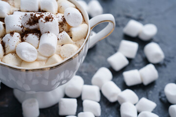 a cup of coffee on a dark table with marshmallows, scattered marshmallows, sweet coffee, cappuccino, latte