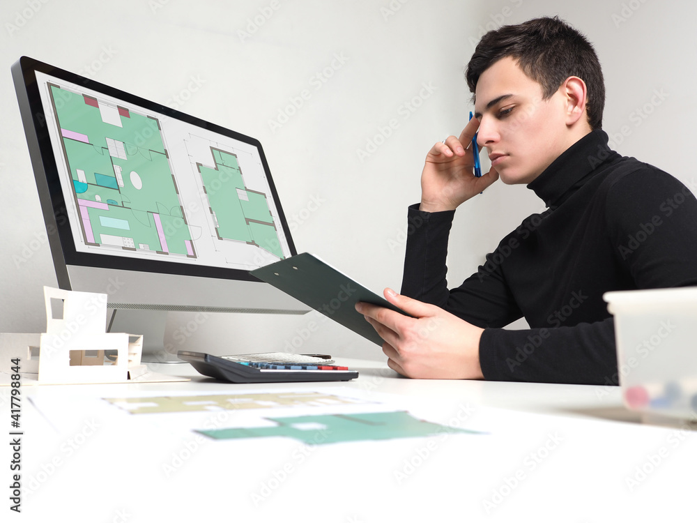 Poster man architect during work. construction drawings on the monitor screen. architect is thinking about 
