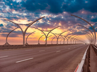Highway with many Lanterns. Automobile road on the background of dawn. Dawn over the track. Sun is...