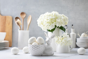 Easter decorations such as a porcelain bunny and eggs on a kitchen countertop