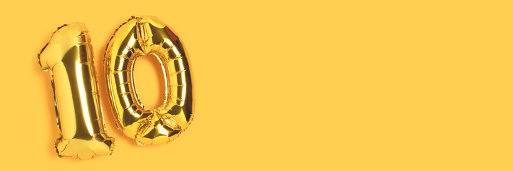 Banner with number 10 golden balloons with place for your design. Ten years anniversary celebration concept on a yellow background.