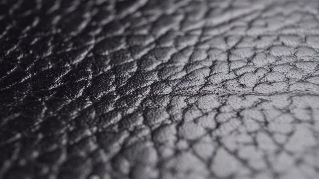 Faux black leather texture. Synthetic Imitation. Macro. Abstract material pattern. Dolly Shot