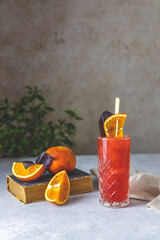 Old-fashioned cocktail garnish slice blood oranges and red basil on the light gray pastel rustic...