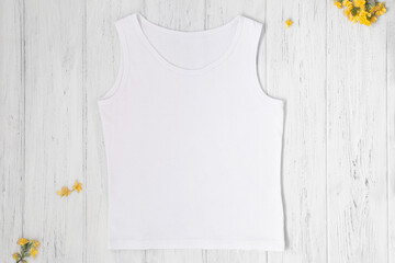 White tank top mockup with spring or summer yellow flowers, flat lay, top view