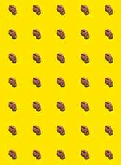 A pattern of roasted coffee beans on a yellow background. Coffee pattern.