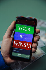 Man holds smartphone with bet application. Gambling and bet concept.