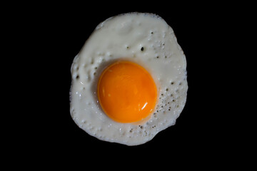 fried egg on black background