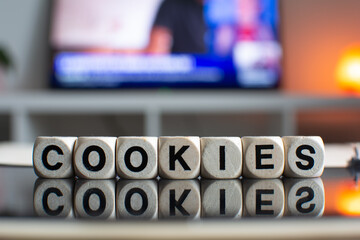 The word cookies written with wooden dices reflecting on a black computer screen 