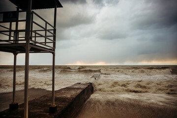 Storm waves near the shore on the beach. In the foreground, breakwaters.