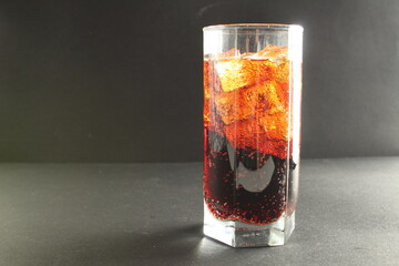 Coca-Cola kvass in an iced glass on a gray background with room to text a cold refreshing summer drink