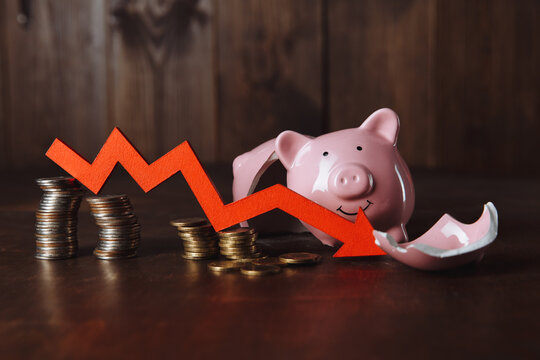 Broken piggy bank and red arrow with coins stack. Investment and bankruptcy concept.