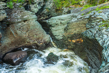 Creek with flushing water eroding a slate rock