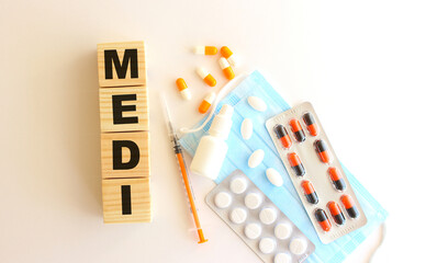 The word MEDI is made of wooden cubes on a white background. Medical concept.