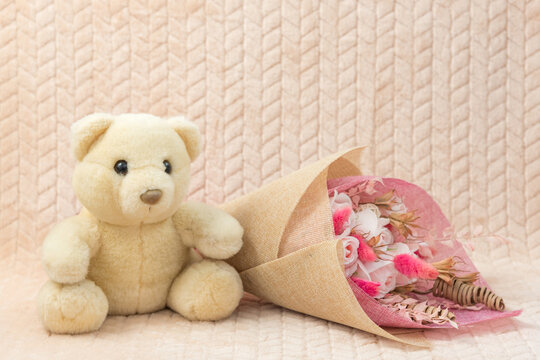 White teddy bear with bouquet flowers