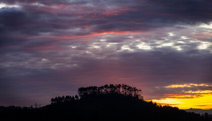 beautiful sunset in the mountains with beautiful colors in a natural environment with trees