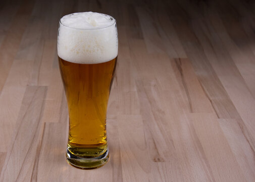 Full glass of beer on the table frame stock images. Fresh lager on a wooden background with copy space for text