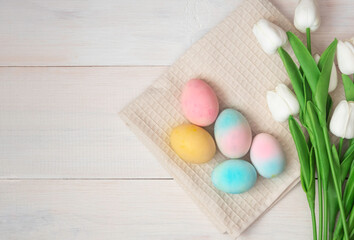 Easter eggs on a fabric backing, wooden background, happy Easter. Top view, flatley.